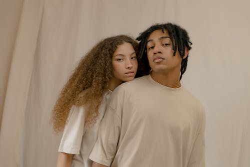 Man and Woman Wearing Crew Neck T-Shirts Standing Close Together