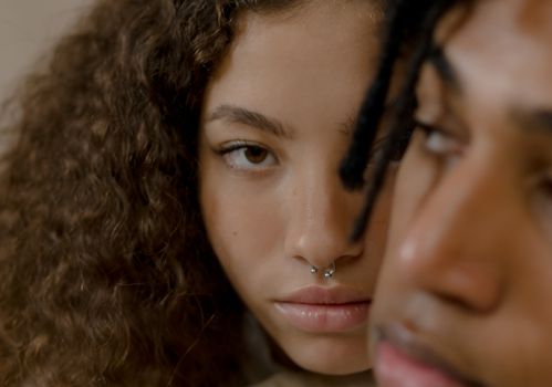 Close-up Photo of a Woman With Curly Hair and Nose Piercing