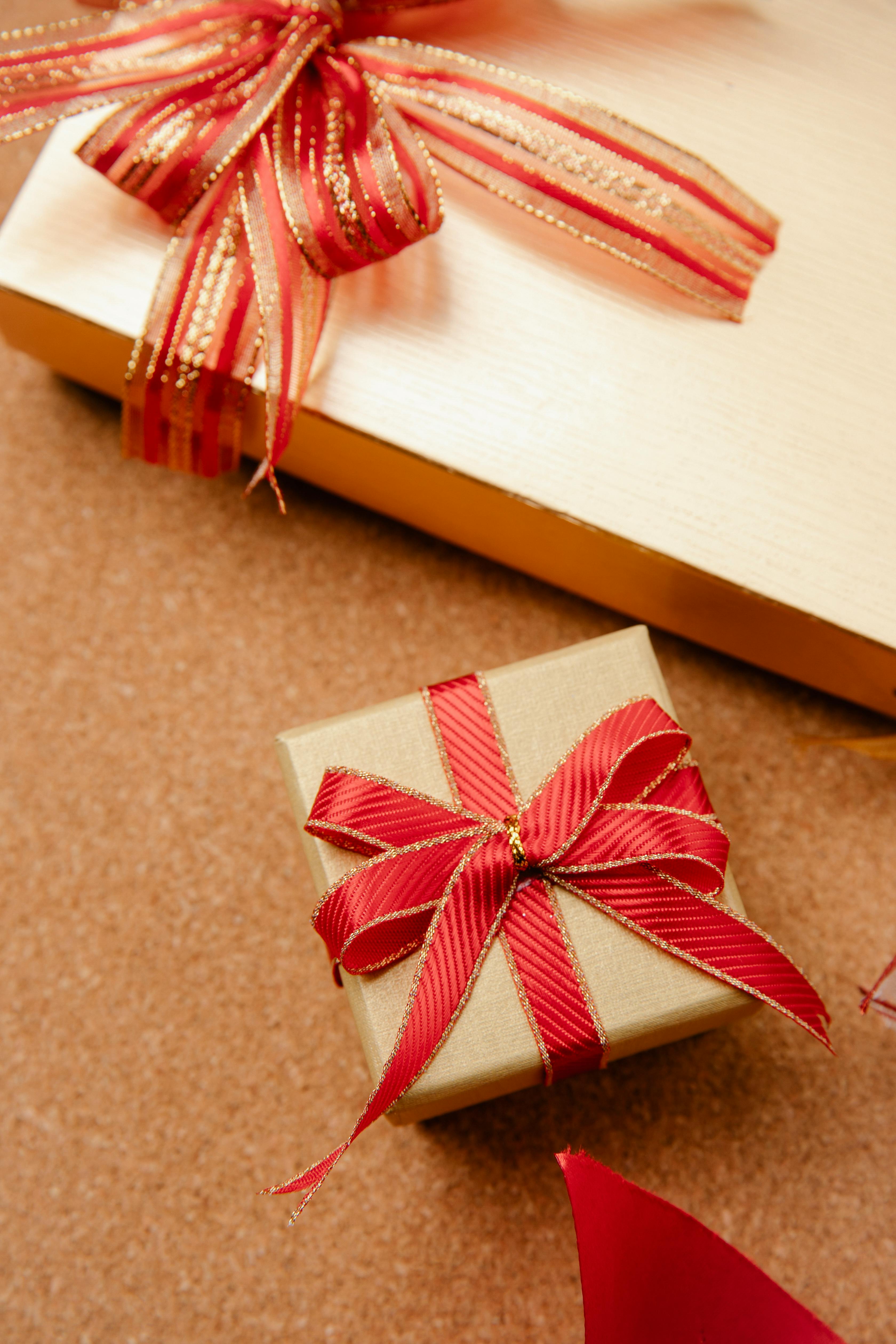 Tangan Menarik Pita Merah Pada Hadiah Yang Dibungkus Kertas Coklat Foto  Stok - Unduh Gambar Sekarang - iStock
