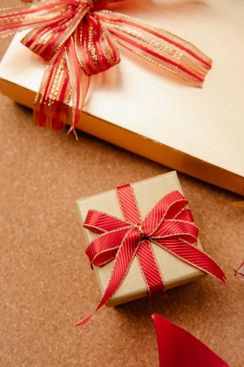 From above wrapped Christmas gift boxes decorated with red ribbons on wooden table