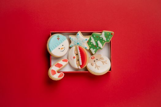 Box with festive Christmas biscuits topped with icing