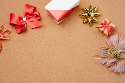 Gift boxes and decorative bows on cork surface