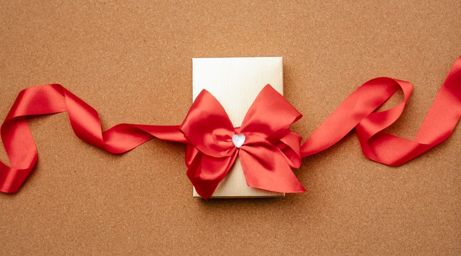 Boîte cadeau bijou emballée avec un ruban rouge et un cœur décoratif