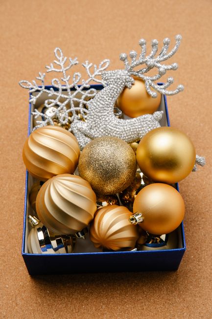 Elegant gold and silver Christmas ornaments in a box for festive decoration.