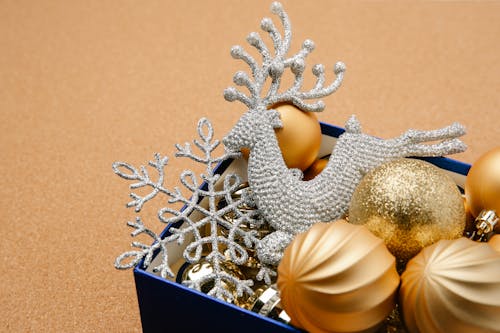 High angle of blue box with Christmas festive golden baubles shiny reindeer and snowflake
