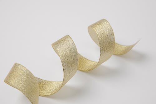Free Wavy golden silky ribbon on table Stock Photo