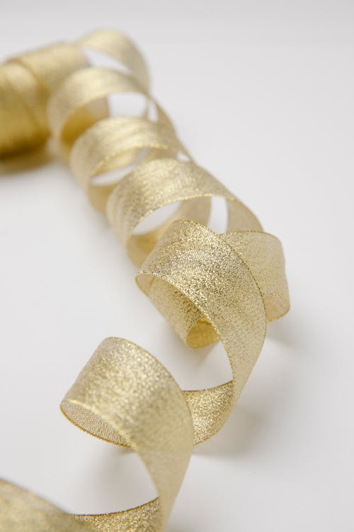 Free Shiny golden twisted ribbon on table Stock Photo