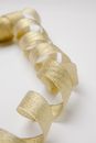 Shiny golden twisted ribbon on table