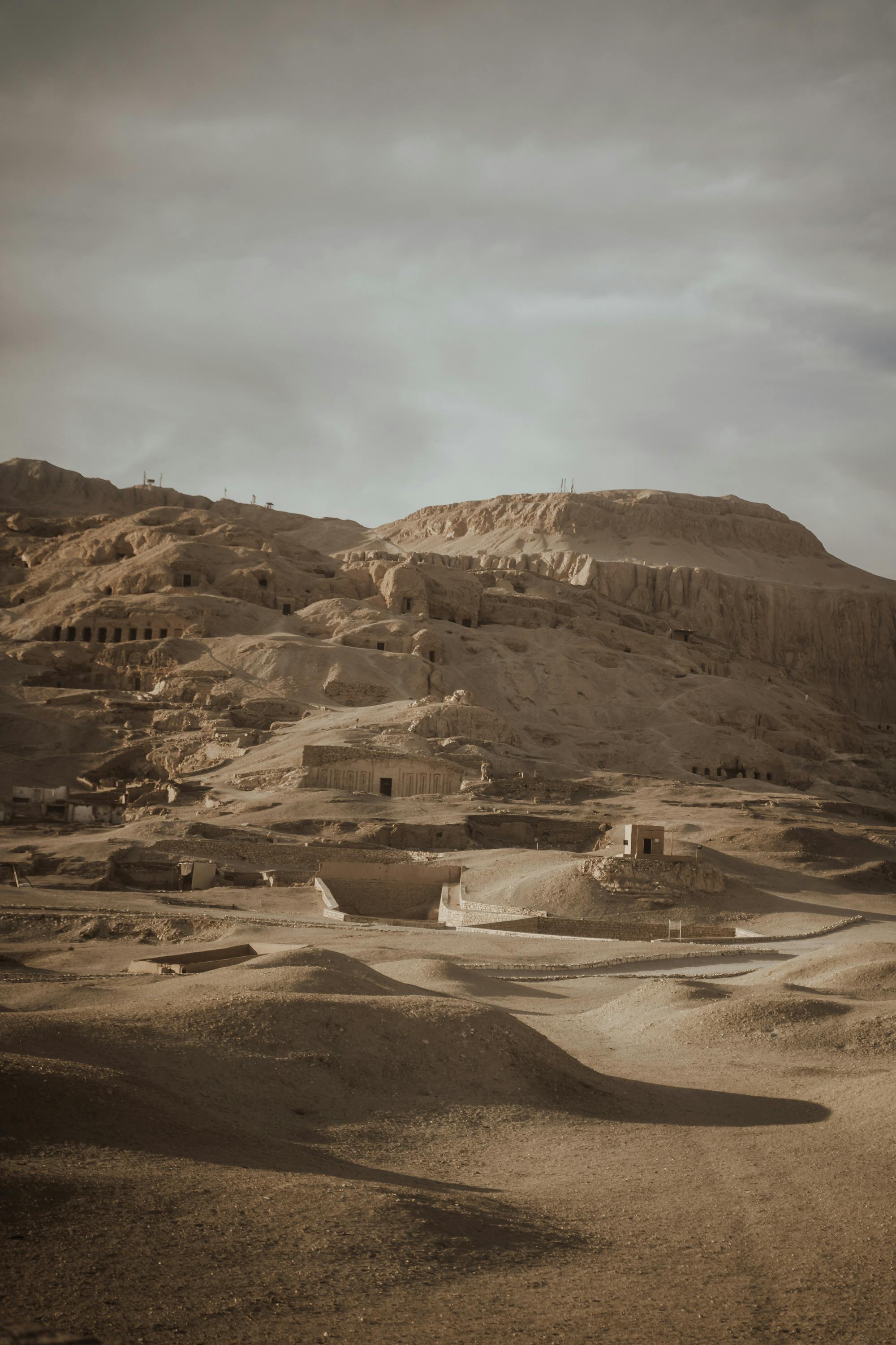 Explore the timeless beauty of ancient Egyptian ruins nestled in the desert hills under a serene sky.