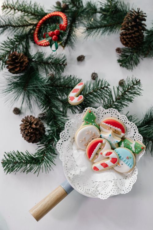 Free From above of composition of Christmas gingerbread and spruce wreath with cones placed on light surface Stock Photo