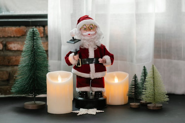 Toy Santa Claus With Candles And Small Fir Trees For Christmas