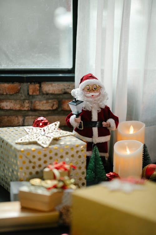 Patung Santa Claus Di Samping Lilin Yang Menyala