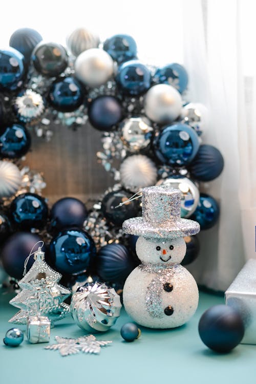 Glowing snowman near blue balls and bright snowflake for Christmas celebration at home