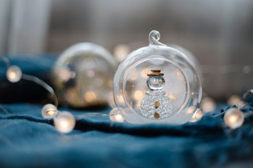 Free Small glass ball with snowman inside and glowing fairy lights as Christmas decorations Stock Photo