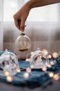 Crop woman putting glass ball on blue cloth