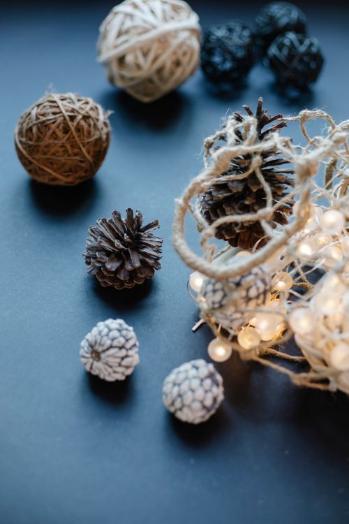Free High angle of mesh bag with burning garland and ball of threads placed with fir cones Stock Photo