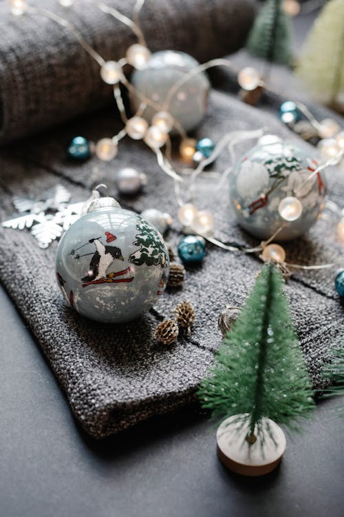 High angle of glass balls arranged with fir cones and star placed near decorative spruce