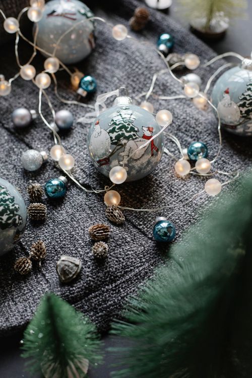 Free From above of different Christmas decorations consisting of baubles garlands and fir cones near evergreen tree Stock Photo