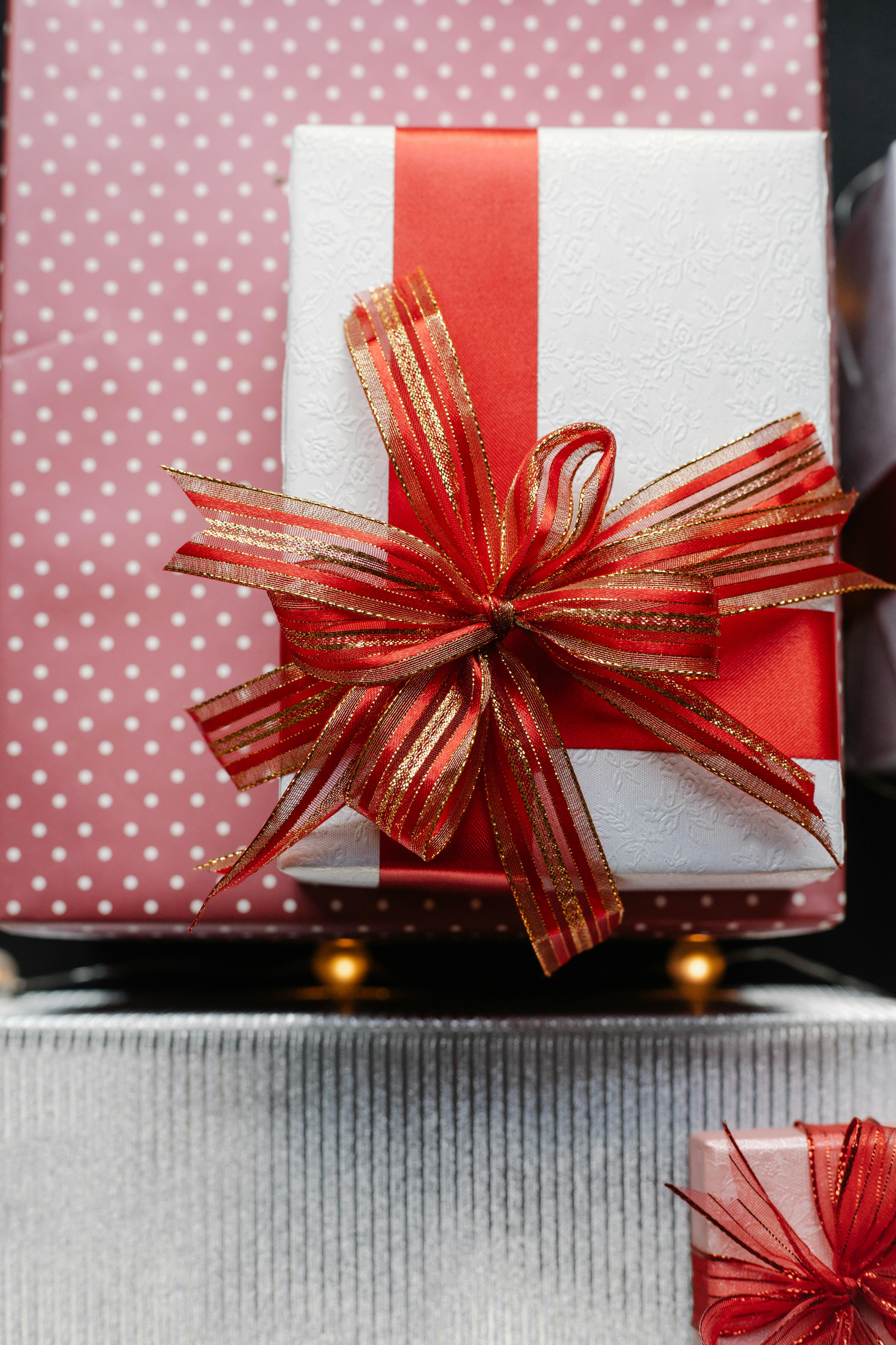 present box with red ribbon on wrapped gifts