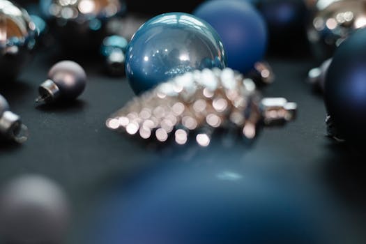 Christmas decorative blue and silver balls with different shape near bump toy in bright place on black background