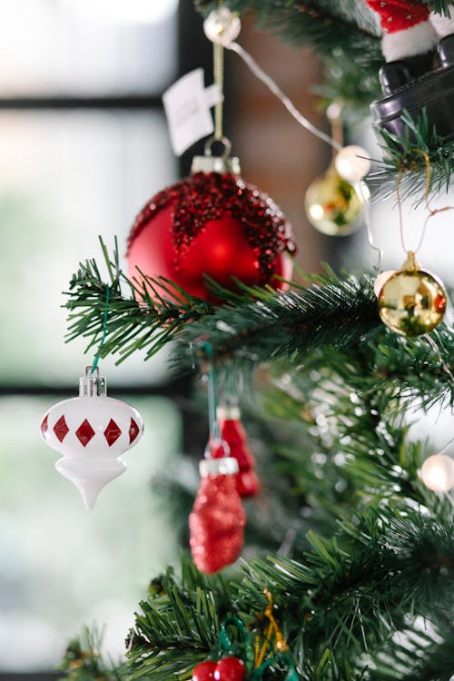 Christmas tree branches decorated with various baubles and fairy lights