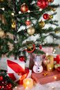 Christmas tree with decor and present boxes near burning candle