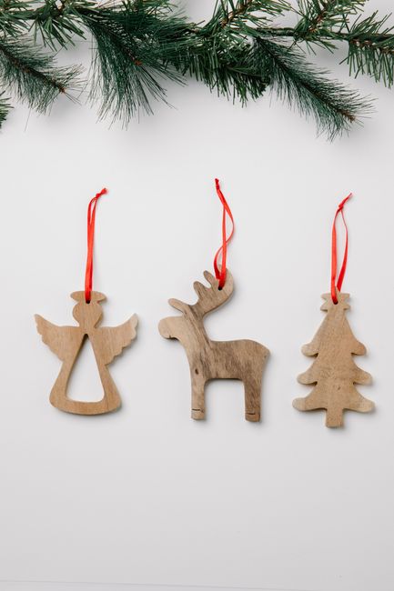 Top view of deer and Christmas tree with angel statuettes near coniferous twig on white background