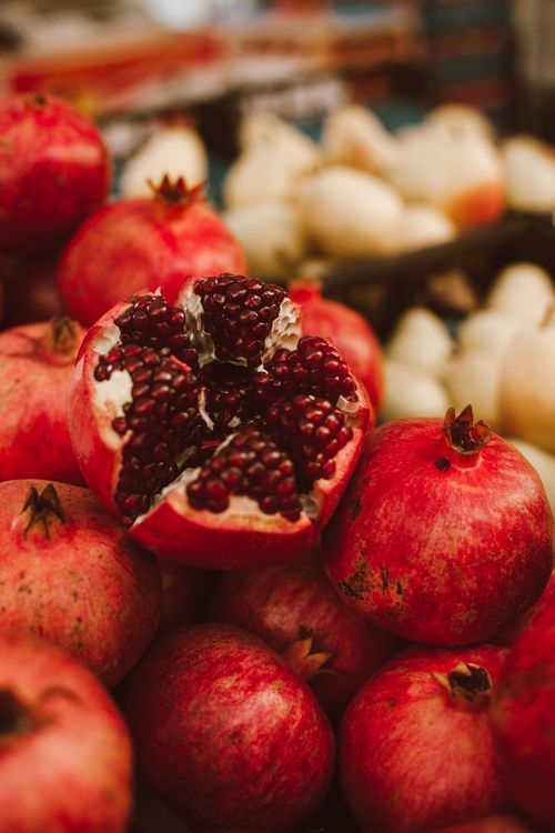 Free Vibrant close-up of a fresh organic pomegranate with seeds exposed, showcasing ripe fruit abundance. Stock Photo