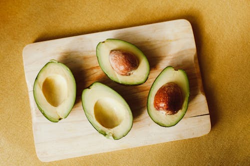 Close-Up Shot of Sliced Avocados on a Wooden Chopping Board