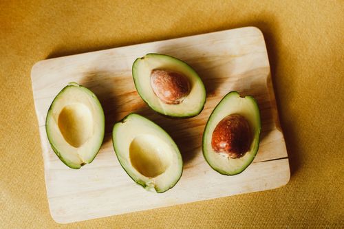Free Top view of fresh sliced avocados on a wooden board, showcasing their vibrant green color. Stock Photo