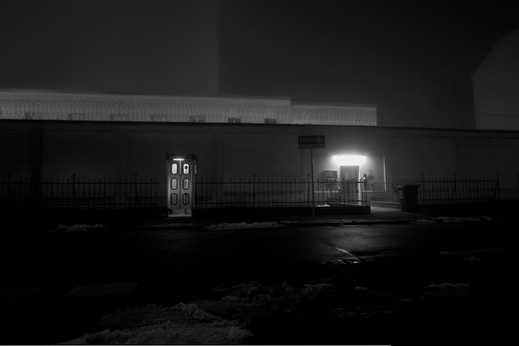 Monochrome Photo Of Fences Near A Building