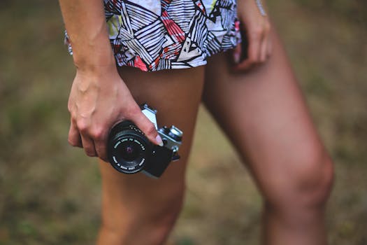 Artistic shot of a woman holding a vintage camera, ready for photography adventure outdoors.