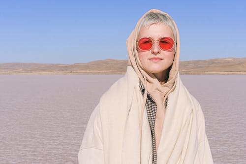 Photograph of a Woman in a Beige Hoodie Wearing Red Sunglasses