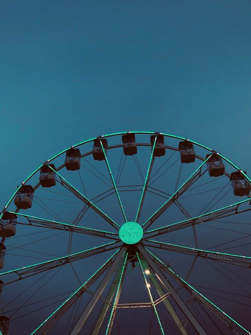 Free A vibrant Ferris wheel illuminated against a dusk sky, creating a striking silhouette. Stock Photo
