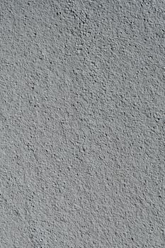 Detailed texture of a rough gray cement wall surface, ideal for backgrounds.