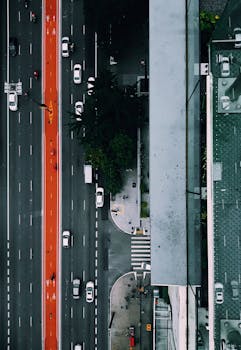 Top-down view of a busy São Paulo street featuring a vibrant red bus lane and adjacent buildings.