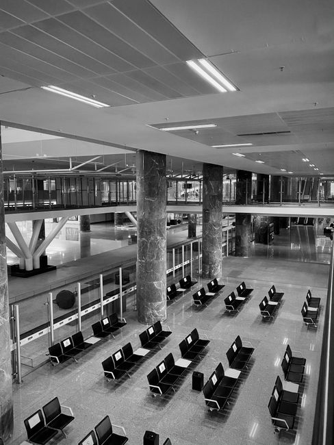 Spacious and empty İzmir airport terminal with modern architectural design.