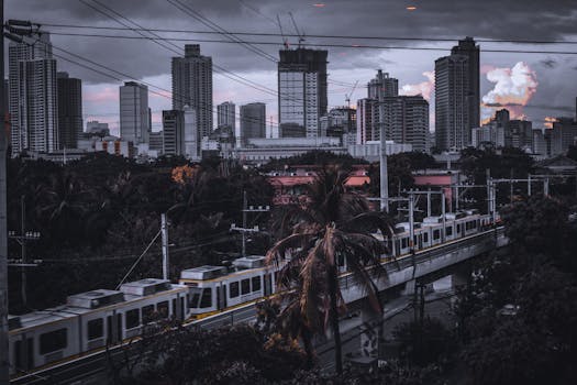 Photo by Joshua Rabusa Dynamic city skyline with a passing train at dusk under dramatic clouds.