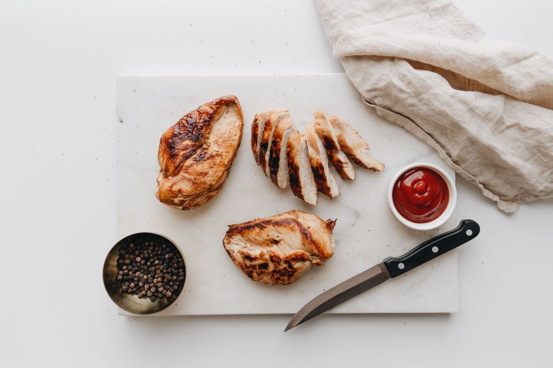 Sliced grilled chicken breast resting on a cutting board. Photo by alleksana on Pexels