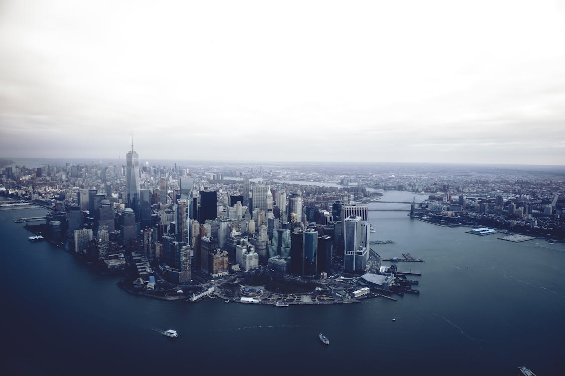 Modern city commercial district located on shore of river on cloudy day