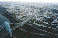 Suspension bridge over river in modern city on overcast day