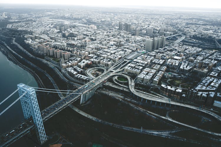 Suspension Bridge Over River In Modern City On Overcast Day