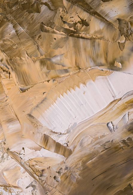 A close-up view of a textured surface with warm, earthy tones and artistic patterns.