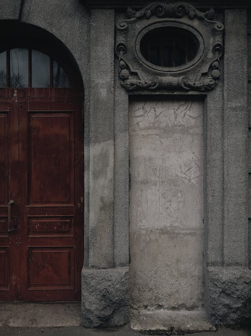 Foto profissional grátis de arcada, parede de concreto, porta de madeira