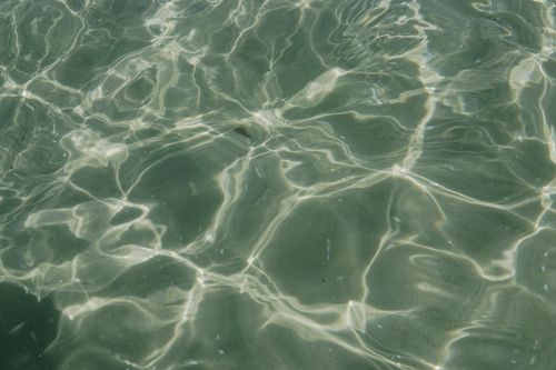 Free Tranquil close-up of gentle water ripples reflecting sunlight, highlighting texture and patterns. Stock Photo