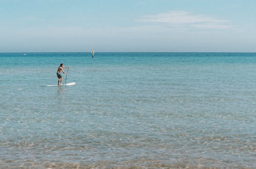 Man in Blue Shorts Surfing on Sea