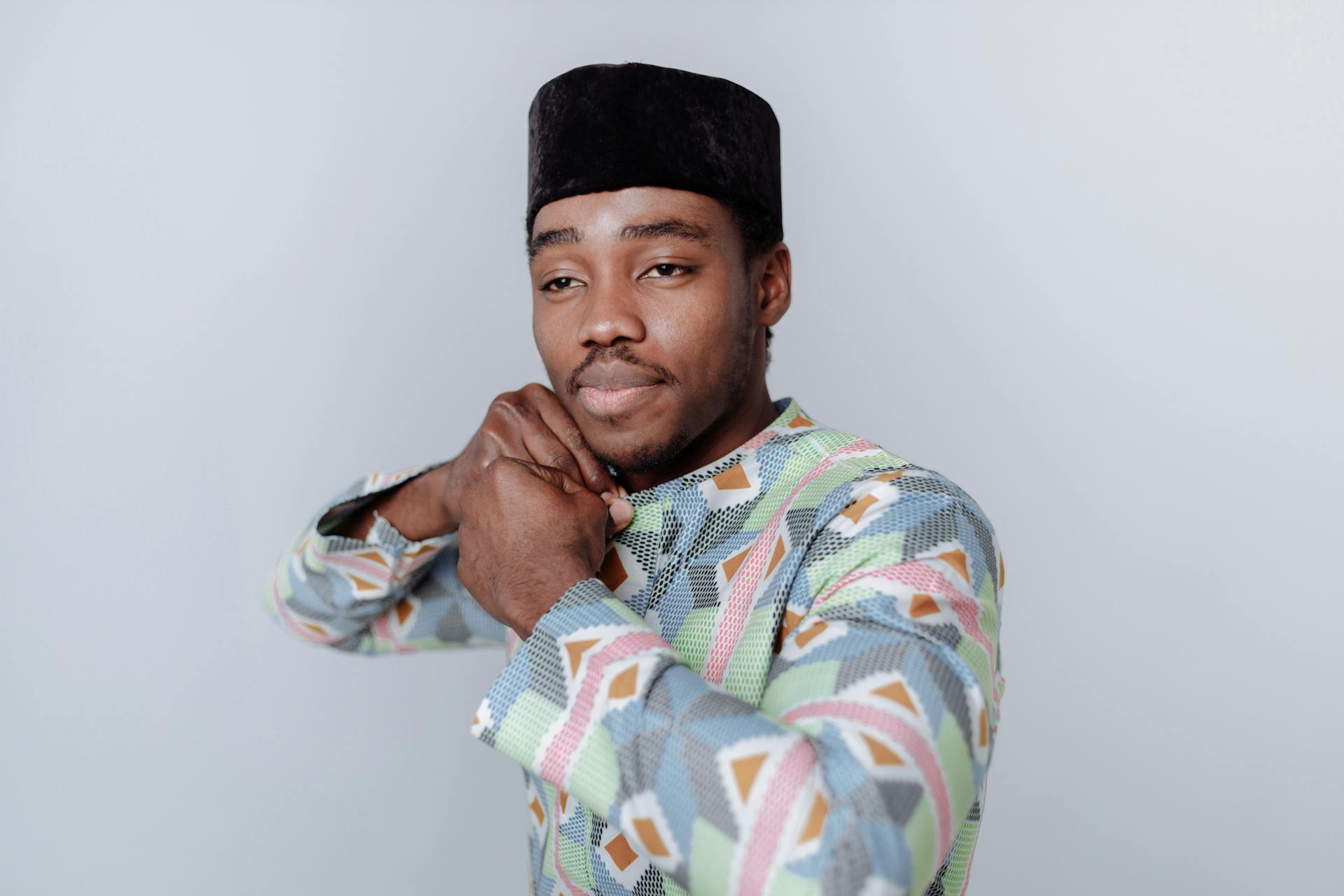 Man in Green and Blue Long Sleeve Shirt Wearing Black Kufi Hat