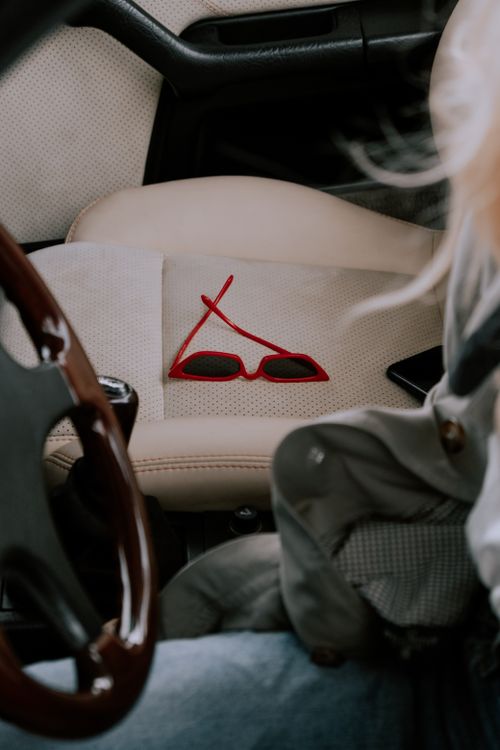 Free Close-up of stylish red sunglasses on a car seat, suggesting a casual road trip vibe. Stock Photo