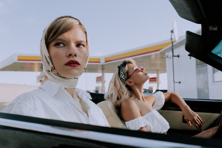 Woman In White Button Up Shirt Wearing Head Scarf Sitting In The Car