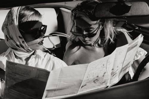 Two Women Sitting in the Car While Looking to the Map